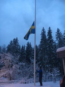 Janis raising the flag to half mast on funeral day. Photo by Peters Zarins, February 2019.